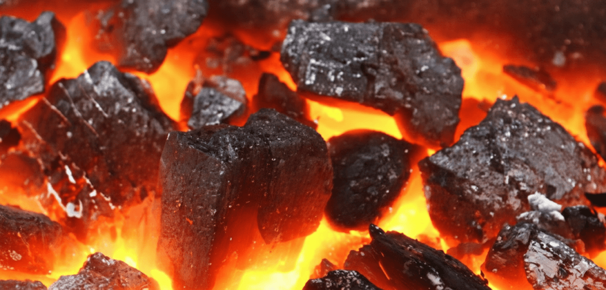 zdjęcie przedstawiające czysty, wysokokaloryczny węgiel spalający się w piecu jasnym płomieniem, ukazujący głęboką czarną barwę i wysoką jakość opału